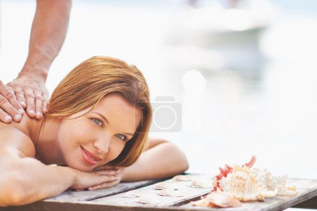 Woman receiving massage on  beach