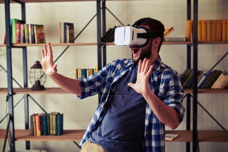 Man having fun using white virtual reality glasses