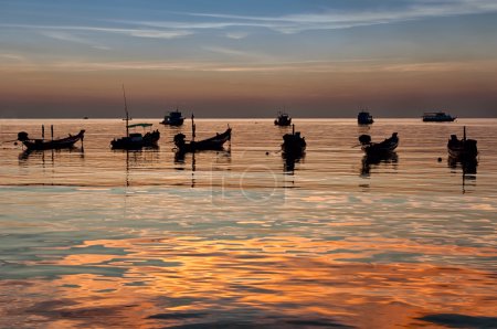 Longtail boats on seashore at sunset, Thailand