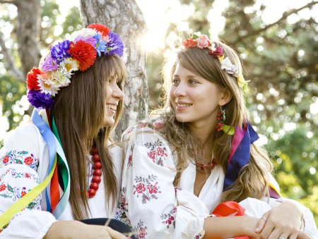 Two girls in national slavic costumes at outdoor.