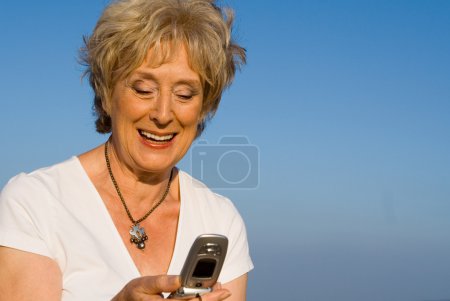 Senior woman texting, with cell or mobile phone