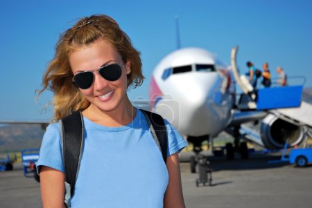 Young woman in front of the airplane