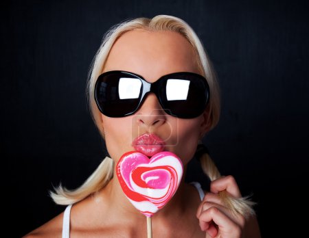 Portrait of young sexy woman with candy