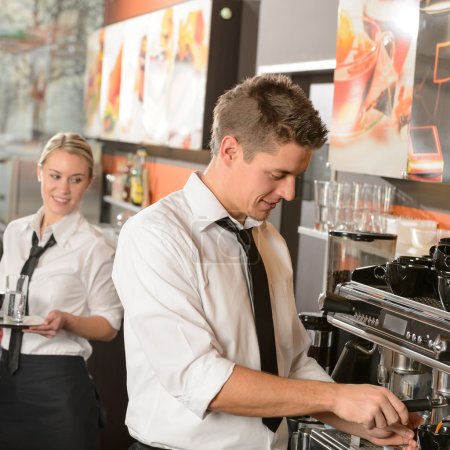 Young waiter and waitress working in bar