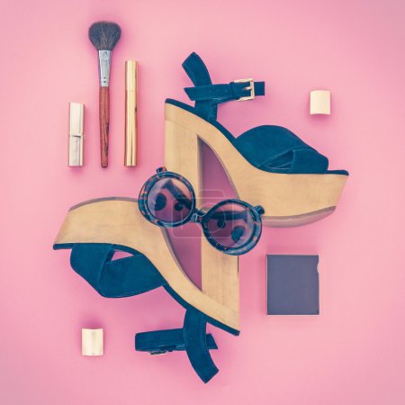 Composition of female accessories and shoes on a pink background