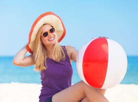 Teen girl with toy ball at the beach.