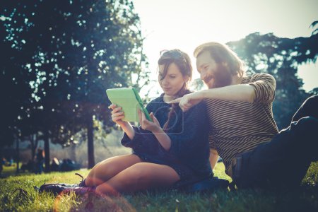 young modern stylish couple using tablet urban
