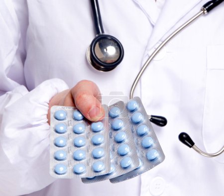 Doctor giving blue medicine pills