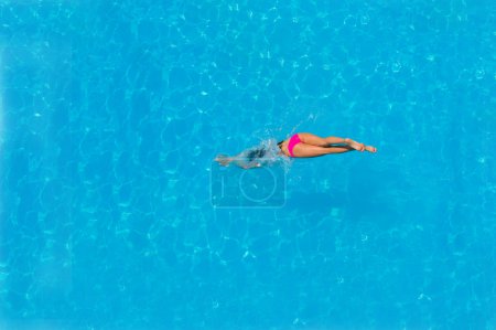 Top view of a girl diving in the pool