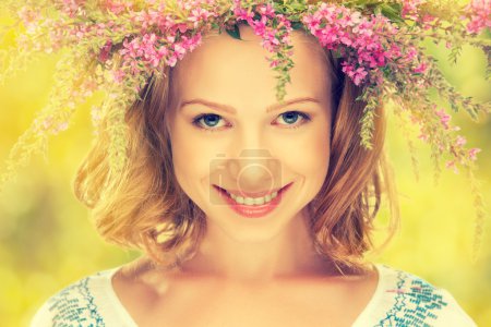 beautiful happy Slavic girl in a wreath of summer flowers