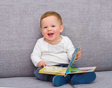 The one-year-old kid sits with the book