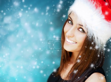 Beautiful woman wearing Santa Claus hat smiling to camera