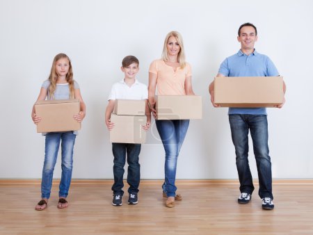 Parents And Two Children With Cardboard Boxes