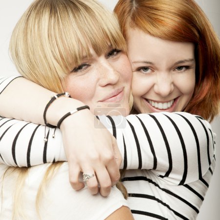 red and blond haired girls laughing and hug