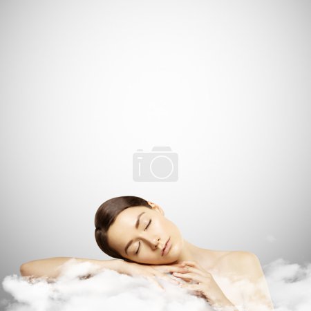 Portrait of a young girl sleeping on a cloud