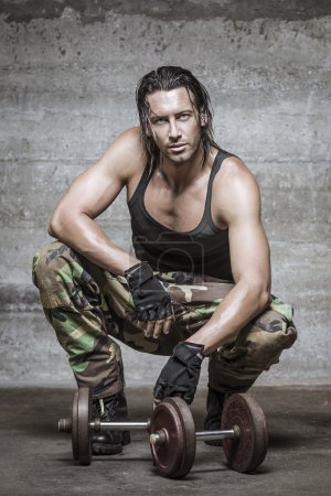 Handsome muscle man wearing camouflage pants