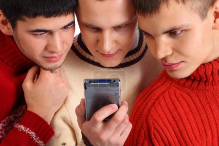 Three friends look on handheld computer