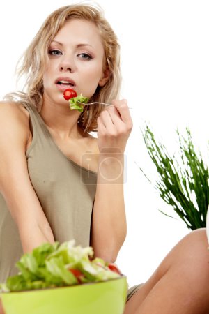 Portrait of young happy smiling woman eating salad