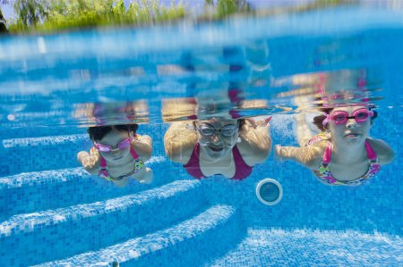 Underwater smiling family having fun and playing in swimming pool