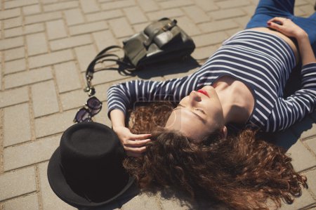 Fashion Hipster Girl laying on street