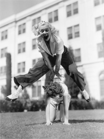 Two women playing leap frog together