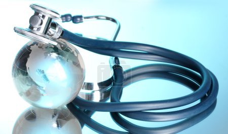 Globe and stethoscope on blue
