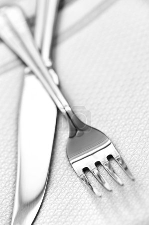 Fork and knife close up on white napkin