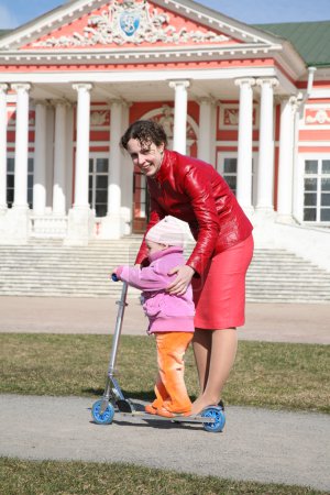 Mother with baby on scooter in kuskovo moscow