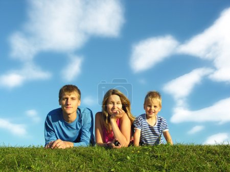 Family on herb under blue sky