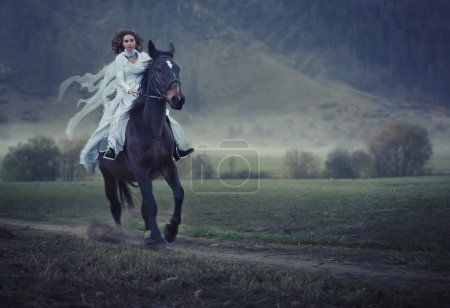 Sensual young beauty riding a horse