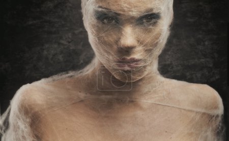 Fine art portrait of a young woman wraped with cowebs