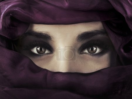 A young middle eastern woman wearing a purple head covering.