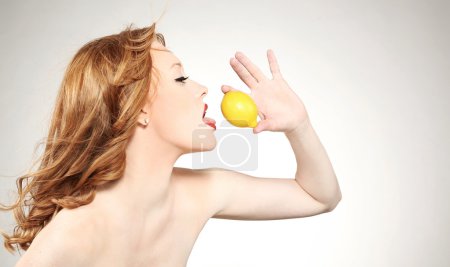 Young attractive woman holding a lemon