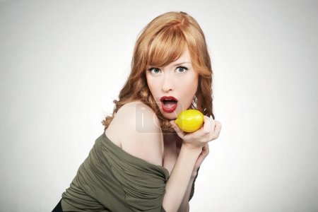 Young happy woman holding a lemon