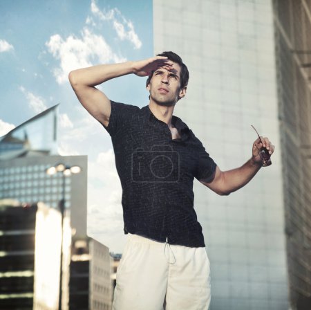 Young handsome man over urban background