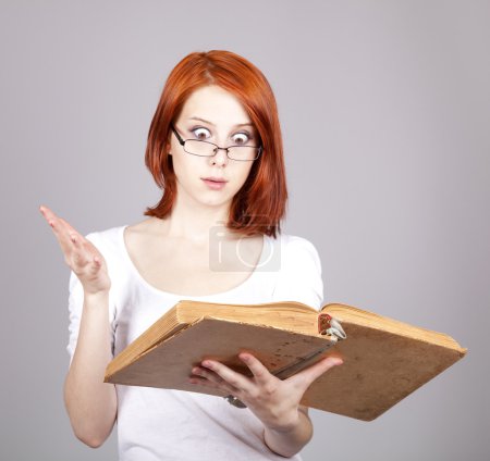 Red-haired smiling businesswoman keep book in hand.