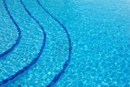Blue background with sun reflected in the swimming-pool water