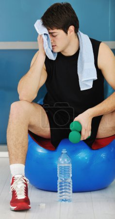 Young man drink water at fitness workout training at sport club