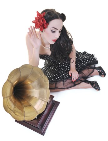 Pretty girl listening music on old gramophone