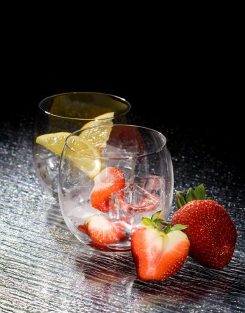 photo of fresh strawberries and lemons on ice cubes