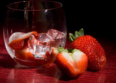 photo of strawberries on ice on red table