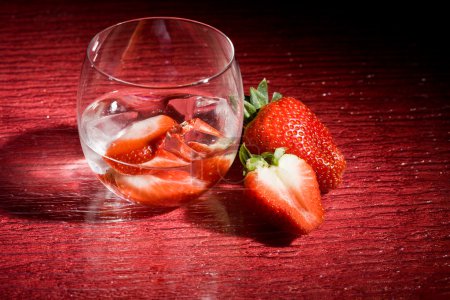 photo of strawberries on ice on red table