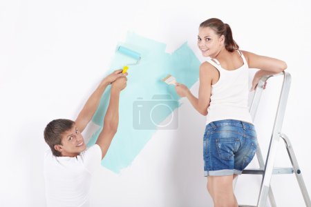 Attractive young couple paint the walls