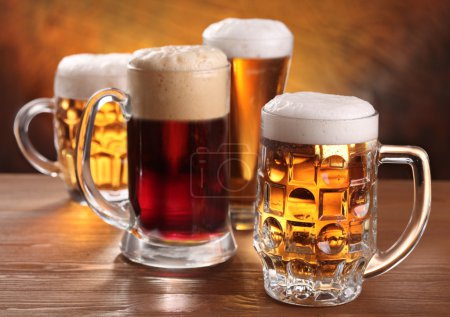 Cool beer mugs over wooden table.