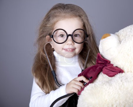 Little girl with stethoscope and bear cub.