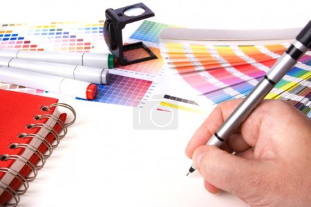 Graphic design and coloured swatches and pens on a desk