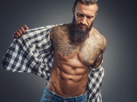 Tattooed male taking off his shirt