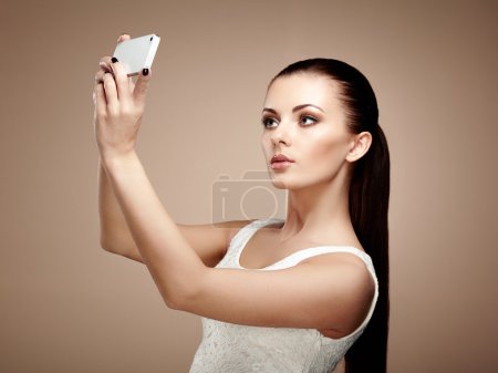 Beautiful young woman taking selfie
