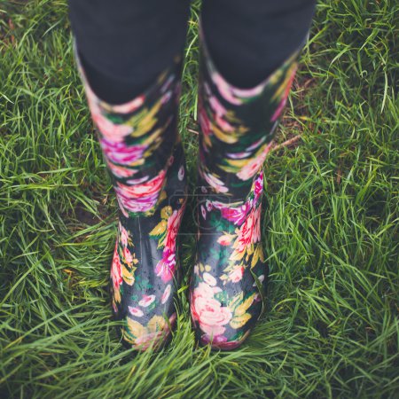woman feet walking in rainboots.