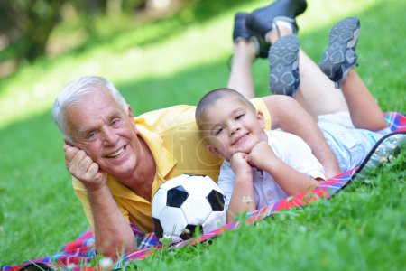 Happy grandfather and child in park